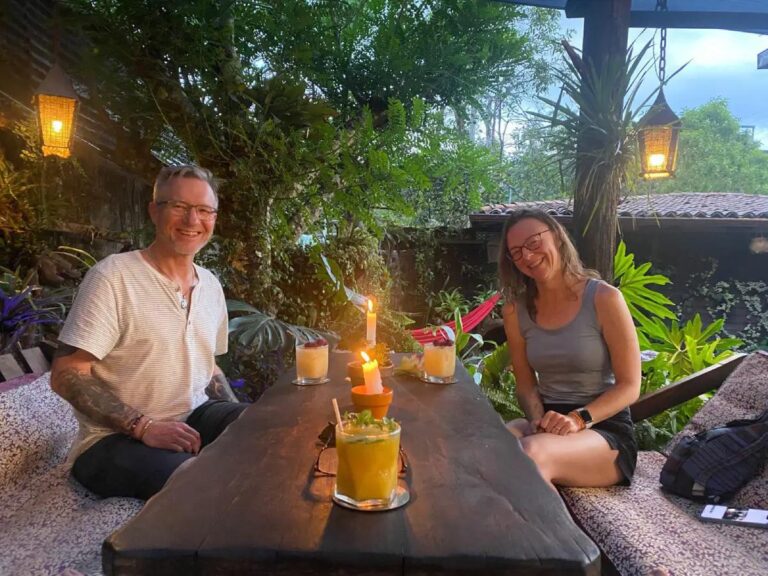 What Is the Cost of Living in Ecuador for Retirees? Retirees relax on a villa veranda in Ecuador's countryside, enjoying coffee and vibrant scenery.