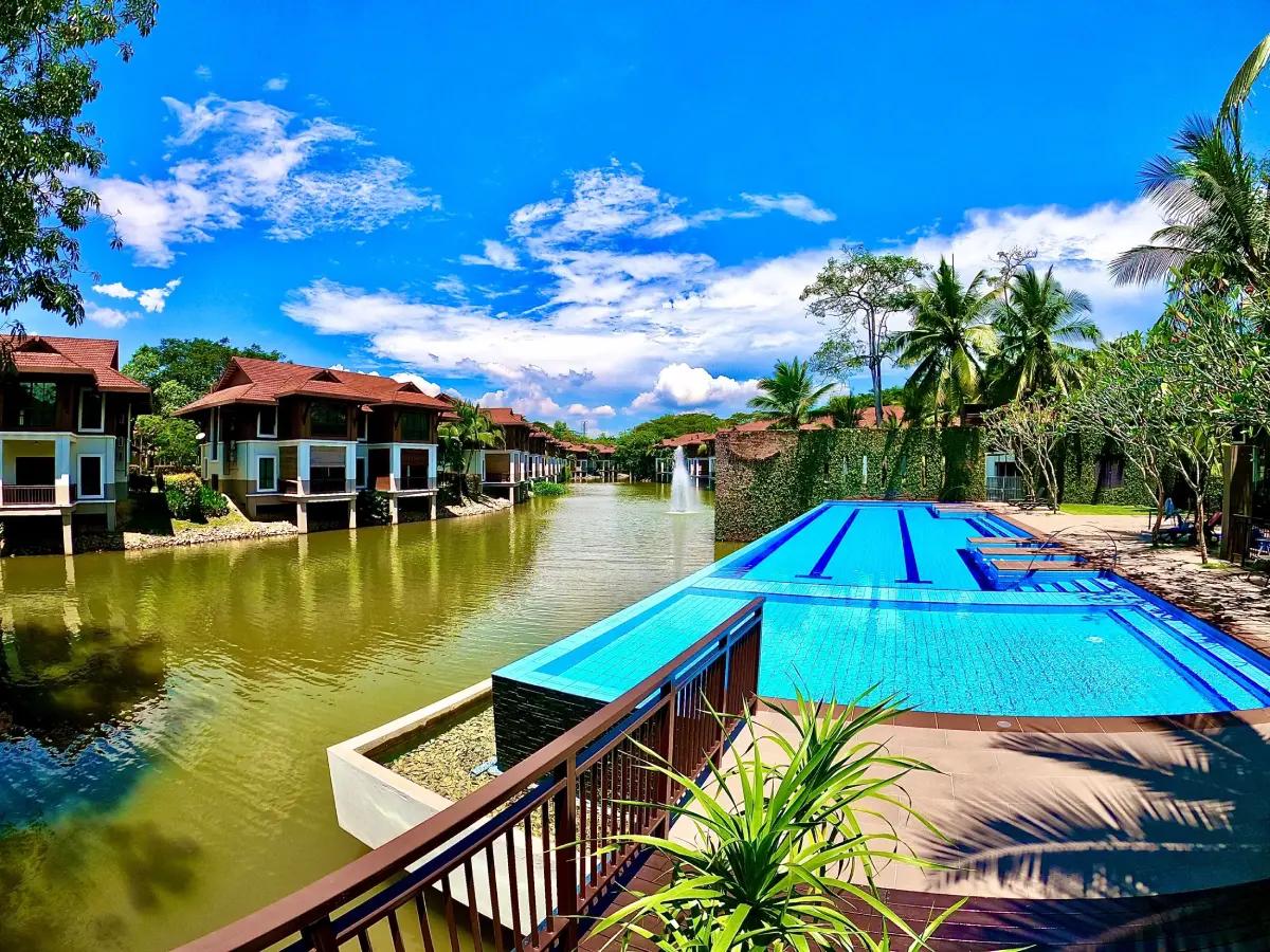 Elderly couple enjoys a morning walk in a serene, lush Malaysian neighborhood.