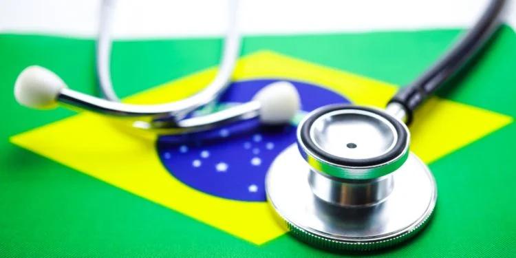 A retired couple converses in a bright, bustling Brazilian healthcare clinic waiting area.