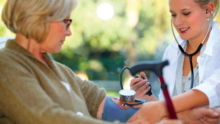 Elderly couple interacting with a nurse in a bright, modern French clinic, conveying serenity.